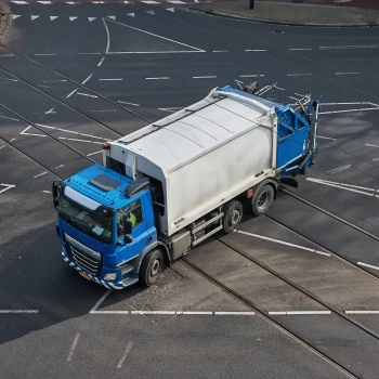Von oben aufgenommenes Abfallsammelfahrzeug auf Fahrbahn.