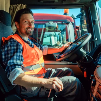 Berufskraftfahrer im Führerhaus eines Müllwagens.